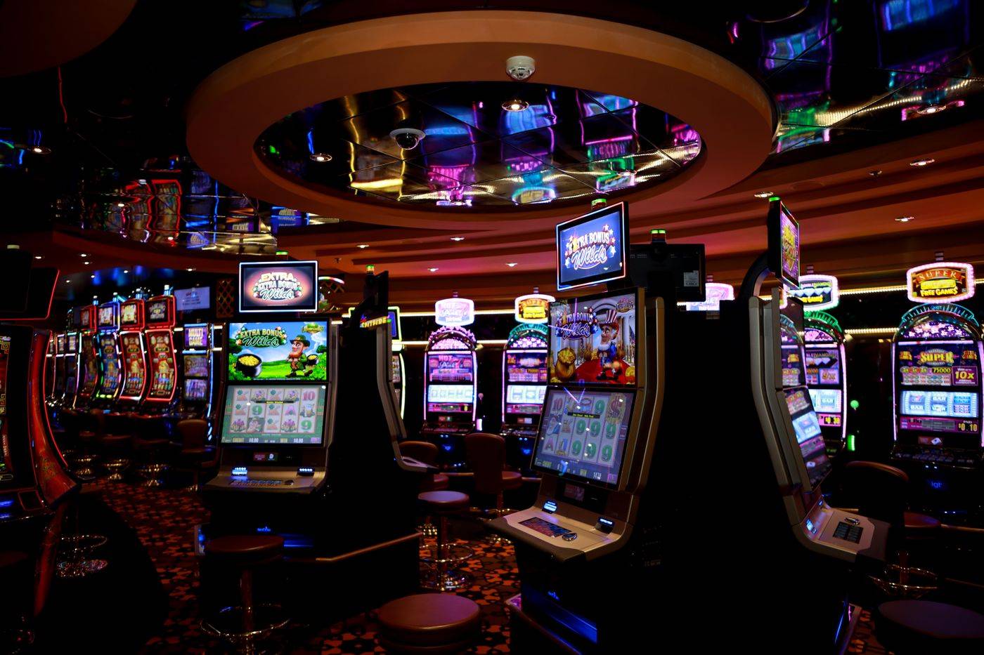 Suasana lantai kasino dengan mesin slot bercahaya warna-warni