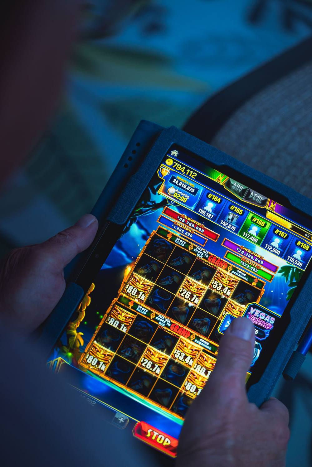 Seseorang bermain gim pada perangkat tablet sambil bersantai